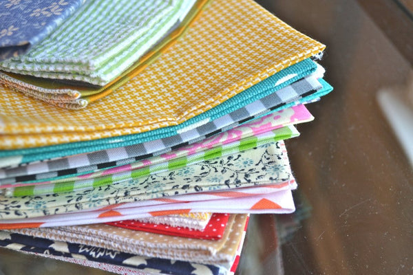 bargain stack of cloth napkins with variety of patterns close up
