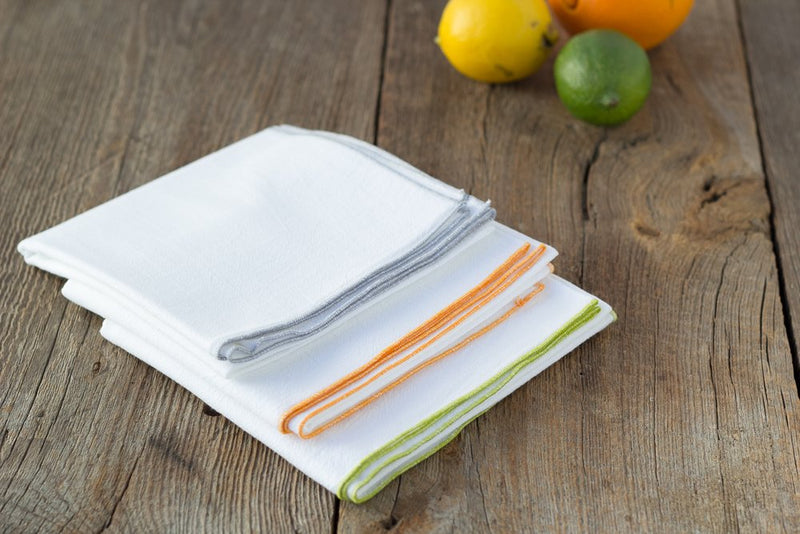 close up of four sack towels with fruit on wooden table