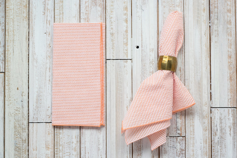 orange colored seersucker cloth napkins on table